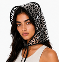 Black leopard print rain bonnet with black trim and chin ties, worn by a model facing the camera.